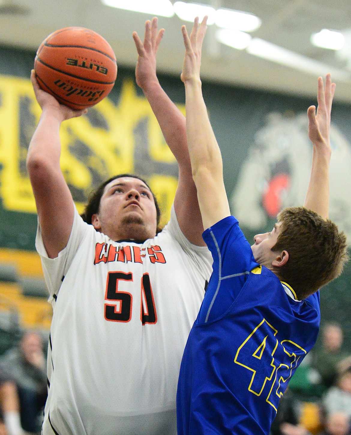 Ronan's Anthony Camel (50) drives to the basket with Libby's Keith Johnson (42) defending at Whitefish High School on Thursday. (Casey Kreider/Daily Inter Lake)
