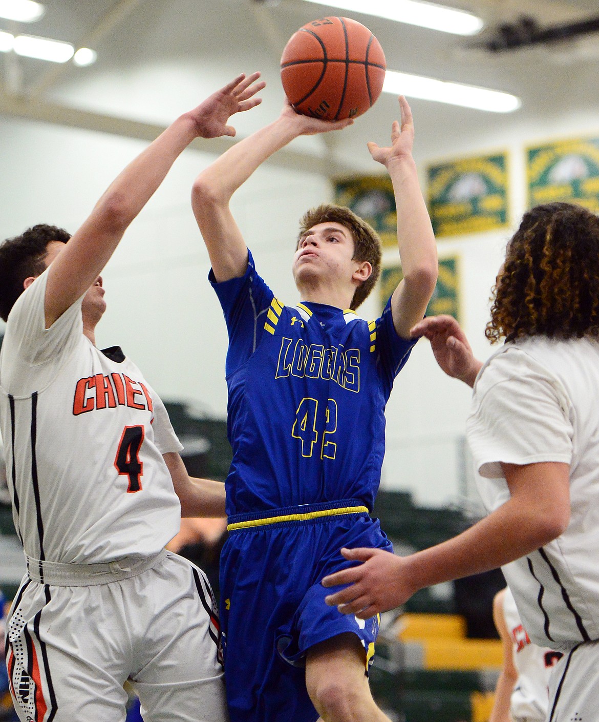 Libby's Keith Johnson (42) drives to the basket between Ronan's Dallas Durheim (4) and Anthony Camel (50) at Whitefish High School on Thursday. (Casey Kreider/Daily Inter Lake)