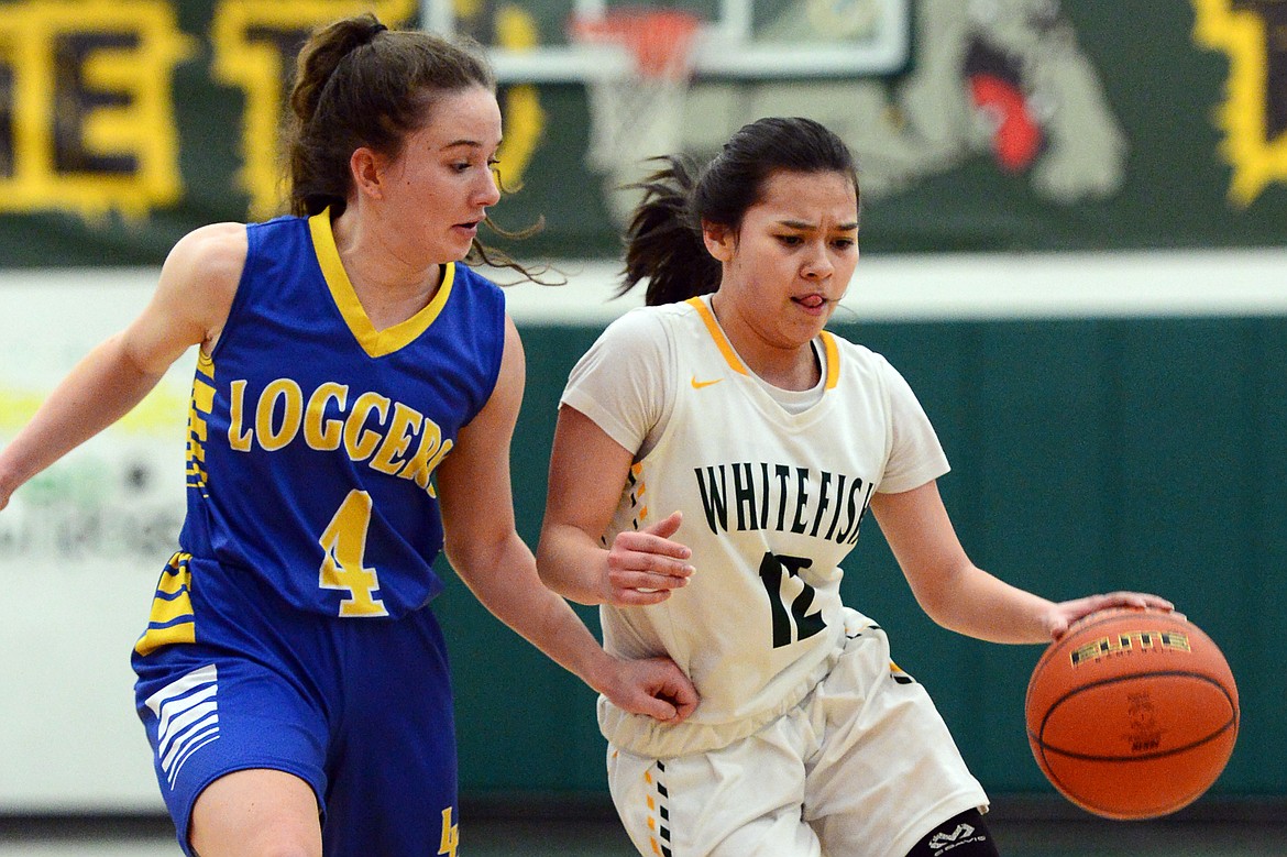 Whitefish's Jasmine Matern (12) brings the ball upcourt under pressure from Libby's Emma Gruber (4) at Whitefish High School on Thursday. (Casey Kreider/Daily Inter Lake)