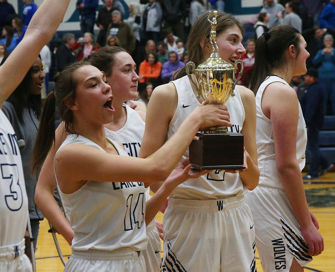 Lake City&#146;s Dejah Wilson, left, and Sara Muehlhausen hold the 5A Region 1 girls basketball championship trophy after defeating Coeur d&#146;Alene 44-30.