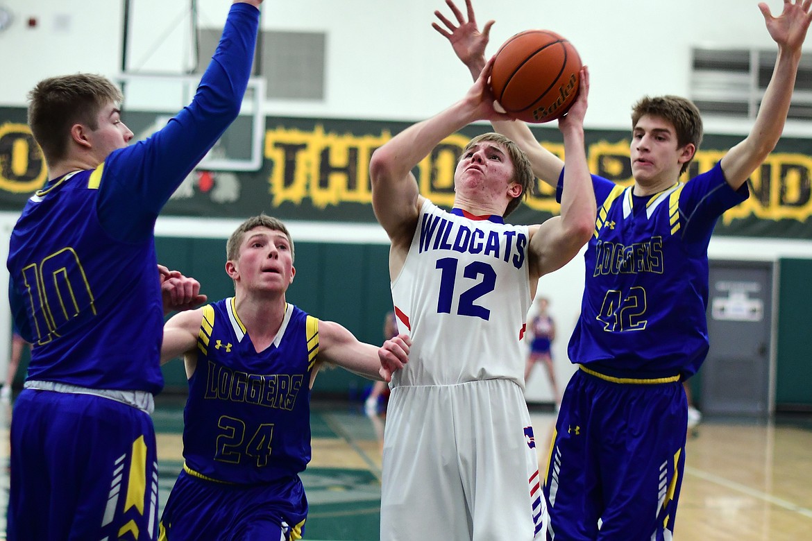 Drew Morgan is surrounded by Libby defenders as he takes a shot against the Loggers Saturday. (Jeremy Weber photo)