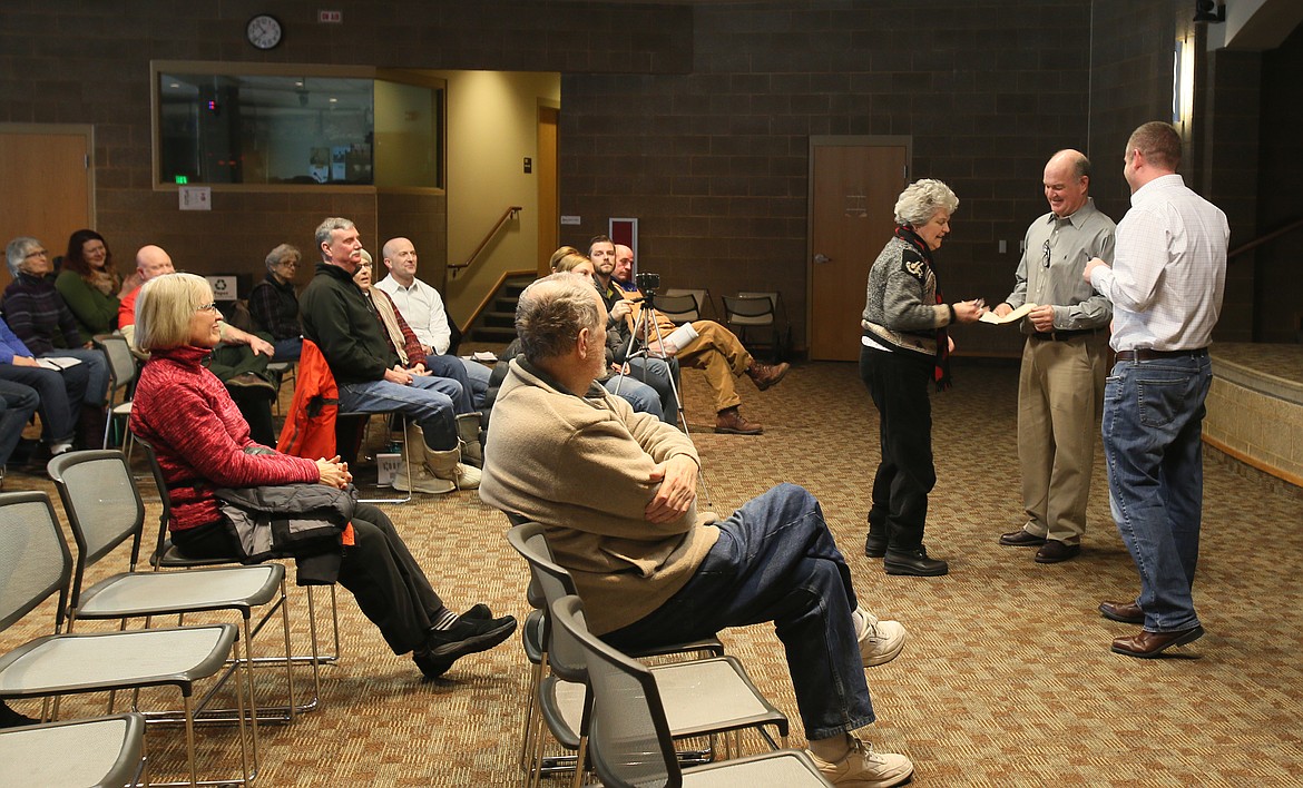 Paula Marano of Coeur d'Alene gives Reps. Jim Addis and Paul Amador decks of cards during a town hall Saturday morning to remind them and their fellow legislators to &quot;not stack the deck&quot; when it comes to redistricting. (DEVIN WEEKS/Press)