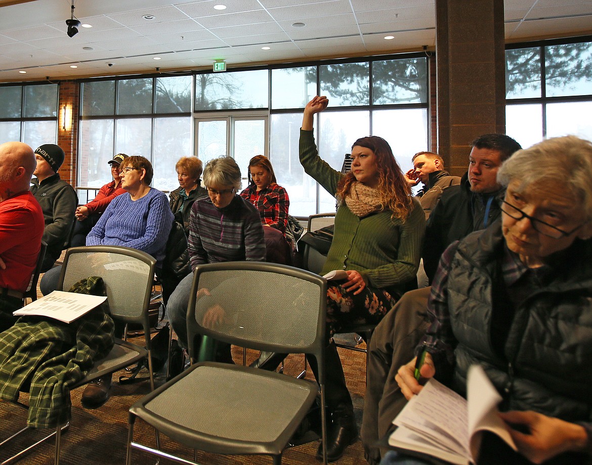 Jessica Mahuron of Coeur d'Alene raises her hand during a town hall meeting Saturday to ask Reps. Paul Amador and Jim Addis a question about increasing tax revenue . (DEVIN WEEKS/Press)