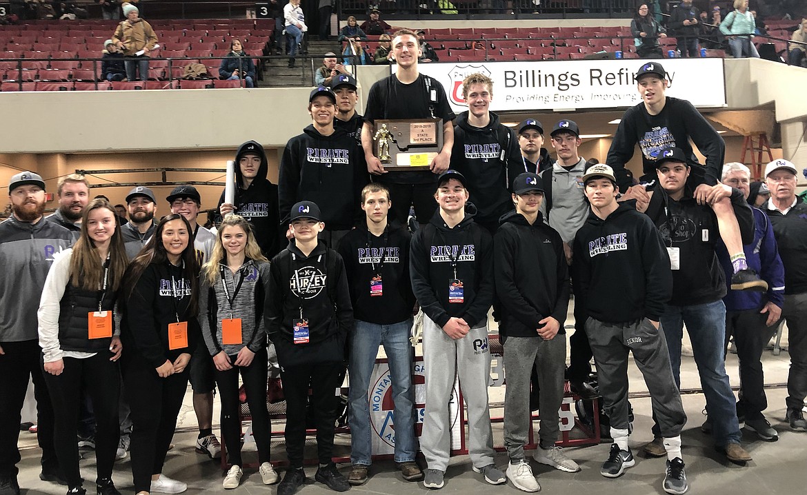 Polson High School teammates, coaches and managers are proudly at the podium in Rimrock Auto Arena at MetraPark in Billings on Saturday to accept the third-place trophy in Class A at the All-Class State Wrestling Championships. Individual state champion Hunter Fritsch holds the team trophy. (Photo courtesy of Kristen Wenzel)