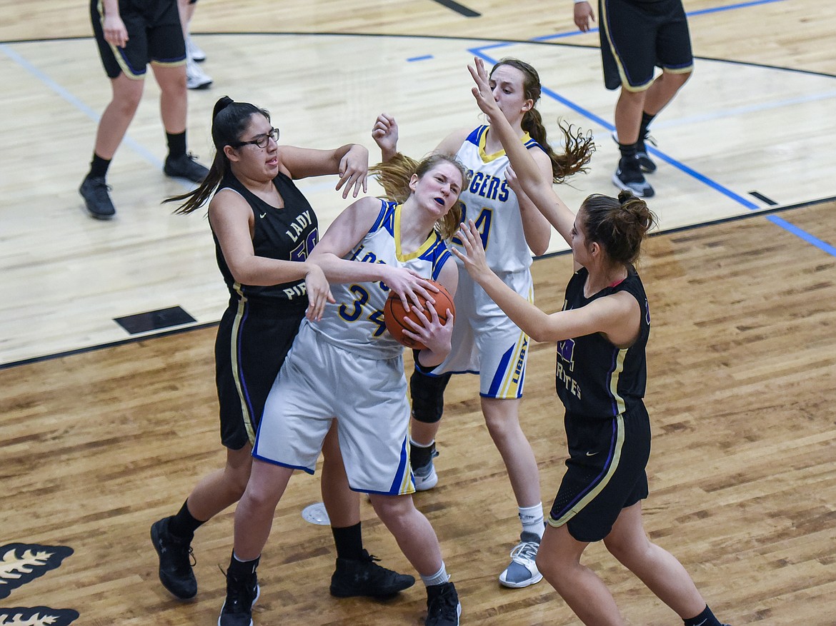 Libby senior McKenzie Proffitt gets the offensive rebound before handing it over to senior Jayden Winslow, who shot for two, in the opening seconds of the fourth quarter Saturday against Polson. (Ben Kibbey/The Western News)