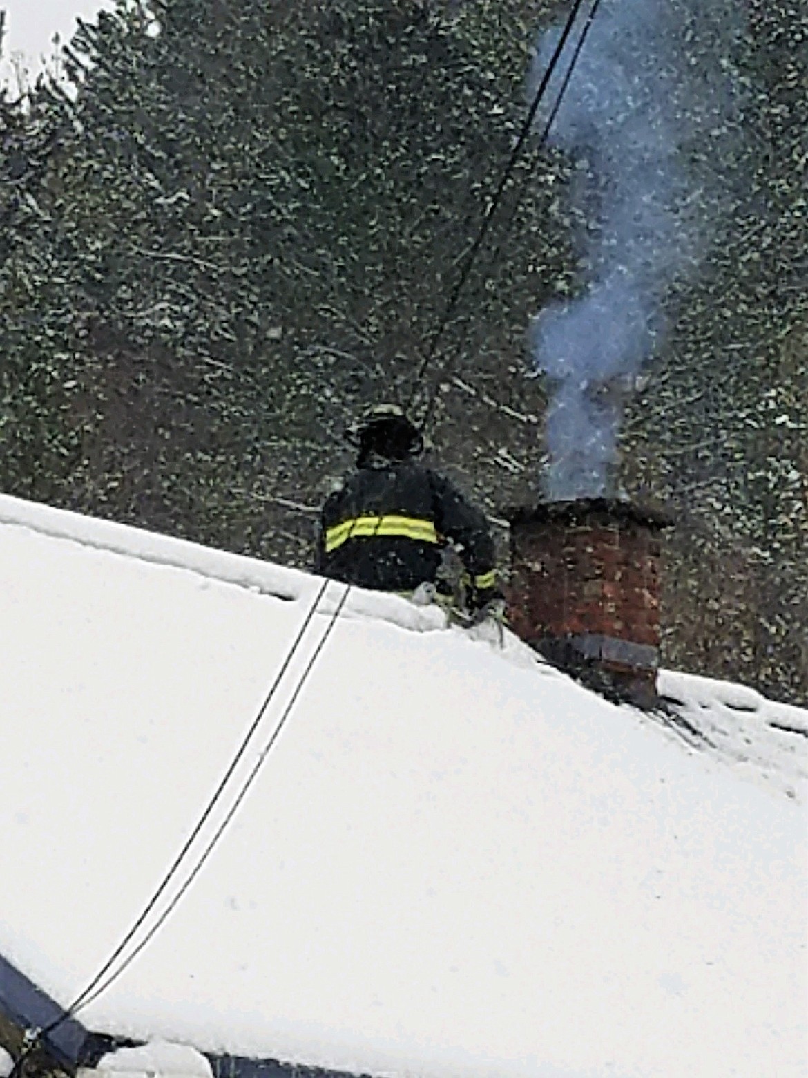 Shoshone County Fire District No. 2 firefighter Lavoryn Nguyen checks out the fire in the chimney on Feb. 6.