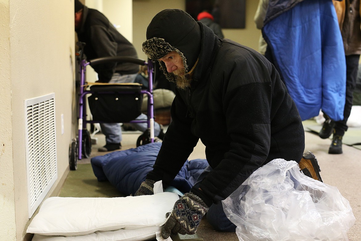 Randy Hausinger organizes his bed inside the warming center in Post Falls last week. The shelter is able to house 40 people and has sleeping bags, blankets, gloves and hot coffee for those in need during the winter months. (LOREN BENOIT/Press)