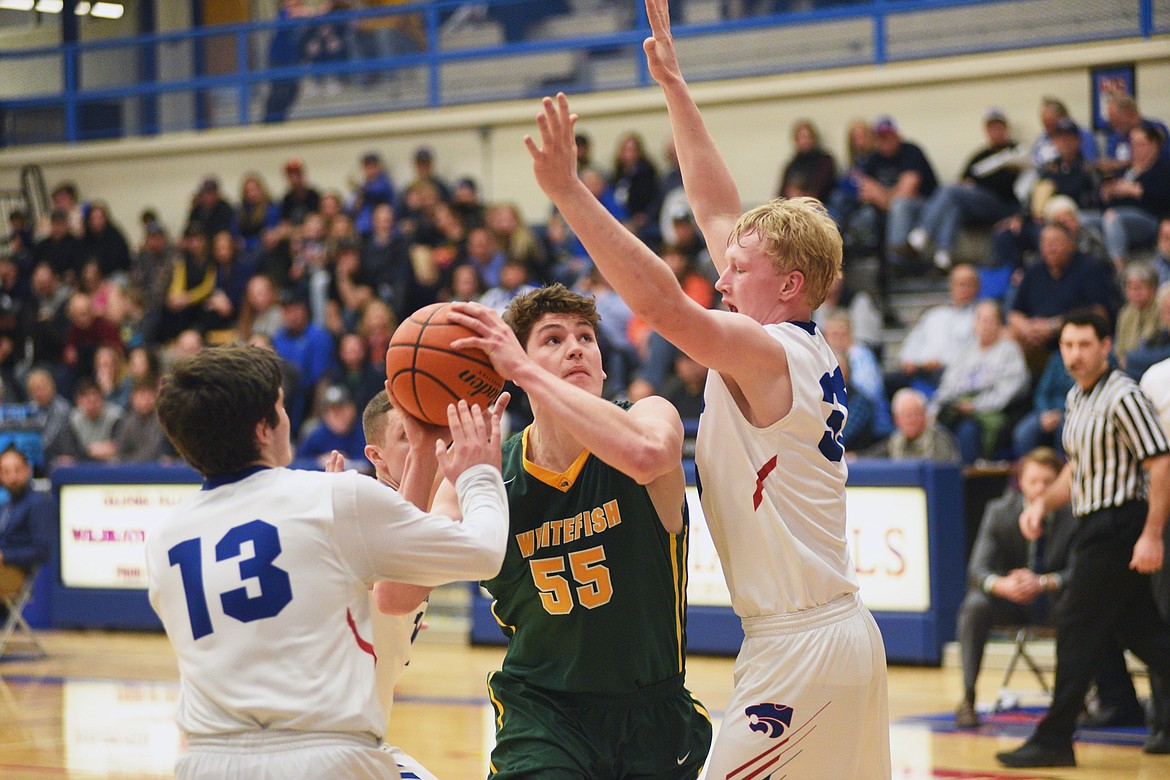 Dillon Botner fights through a pair of defenders during Thursday's 60-39 beatdown of the Wildcats at Columbia Falls. (Daniel McKay/Whitefish Pilot)