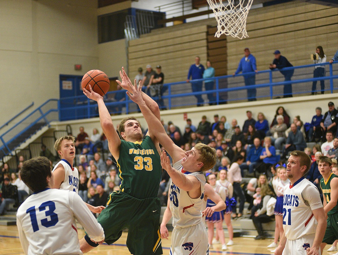 Ryan Kemm fights to get a layup off during Thursday's 60-39 beatdown of the Wildcats at Columbia Falls. (Daniel McKay/Whitefish Pilot)