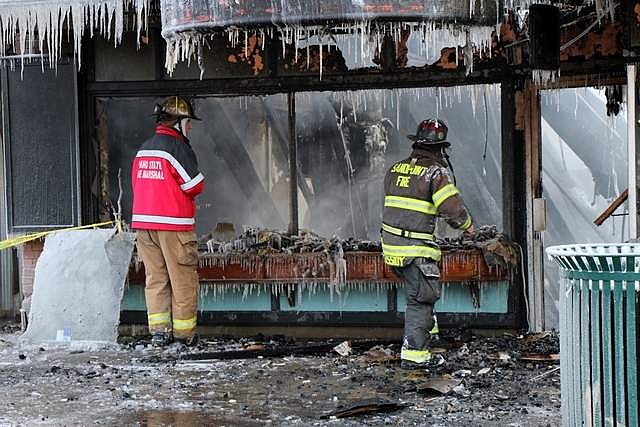 Photo by CAROLINE LOBSINGER/Hagadone News Network
An Idaho State fire marshal joins Selkirk Fire Capt. Glen Cassidy in front of the Headlines hair salon as crews begin what is expected to be a days-long investigation into the fire&#146;s cause.