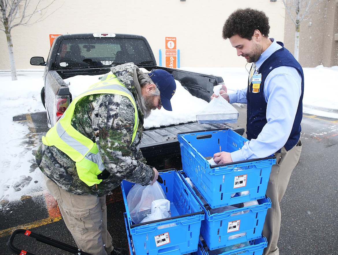 Associate Tim Horn, left, and Assistant Manager Dwain Pettiford load groceries for a customer at a pickup location at Walmart on Wednesday. (LOREN BENOIT/Press)