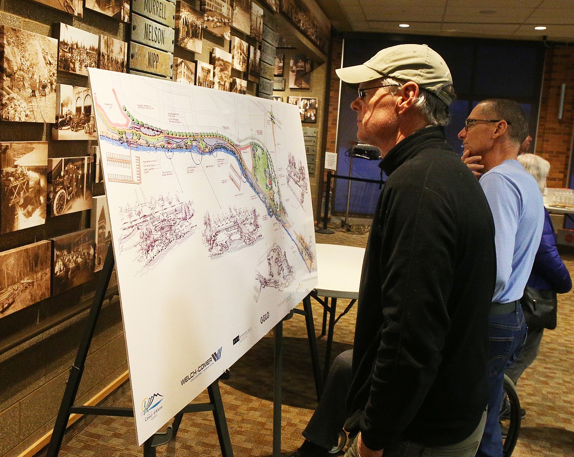 Scott Dickinson of Coeur d'Alene views possible future park plan designs for the 47-acre former Atlas Mill and waterfront site during a open house Monday night at the Coeur d'Alene Public Library. (LOREN BENOIT/Press)