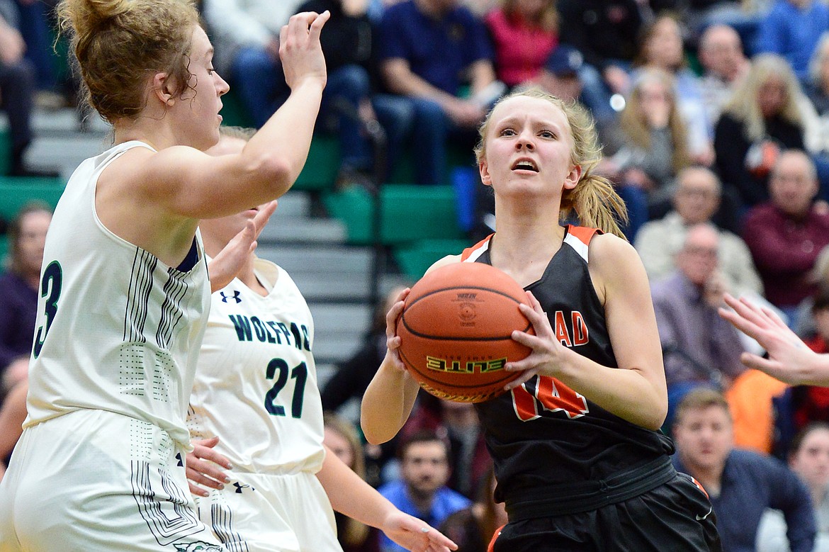 Flathead's Jenna Johnson (14) drives to the hoop with Glacier's Kali Gulick (3) defending during Western AA Divisional play at Glacier High School on Thursday. (Casey Kreider/Daily Inter Lake)