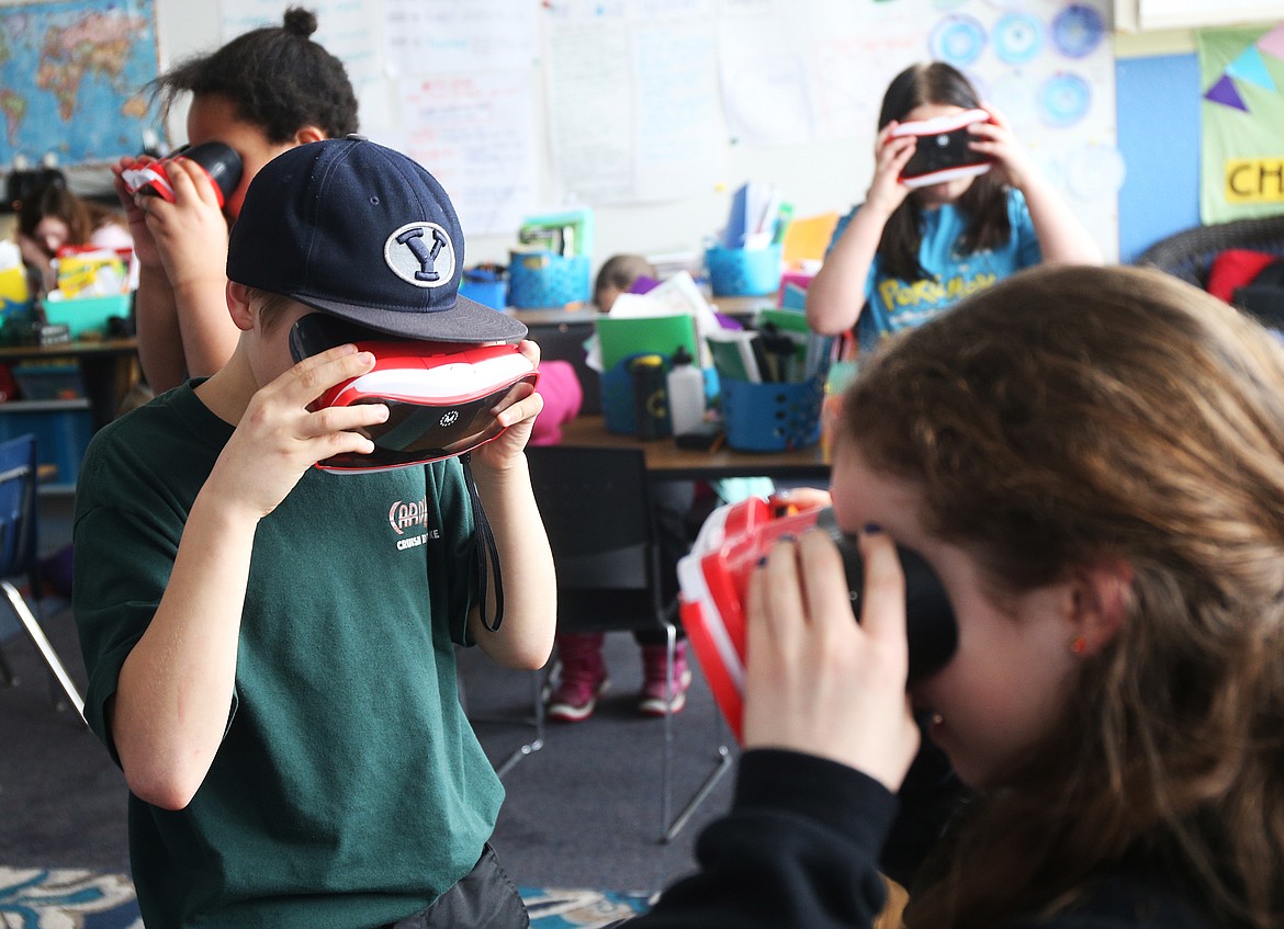 Fifth grade students Markus McFadden, left, and Charli Hidalgo, right, learn lessons about the solar system while using virtual reality headsets during class Wednesday at Northwest Expedition Academy in Hayden. (LOREN BENOIT/Press)