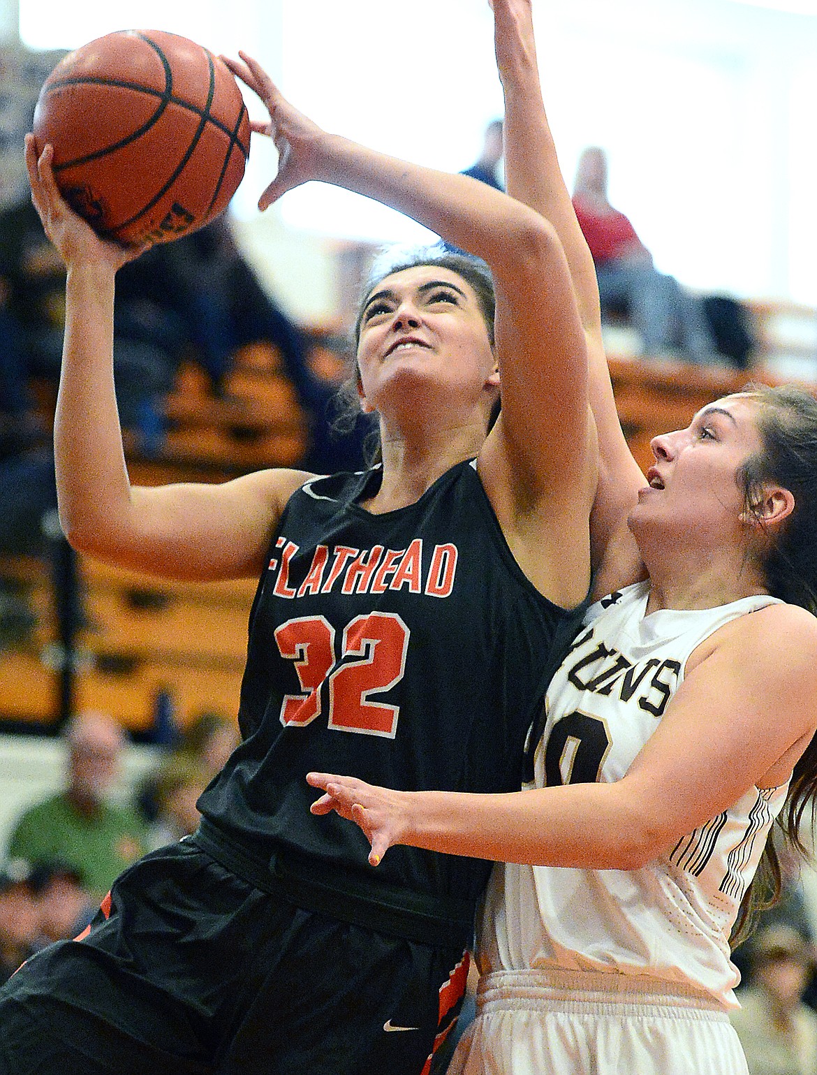 Flathead's Taylor Henley (32) drives to the basket against Helena Capital's Megan Lindbo (20) in the first half at Flathead High School on Saturday. (Casey Kreider/Daily Inter Lake)