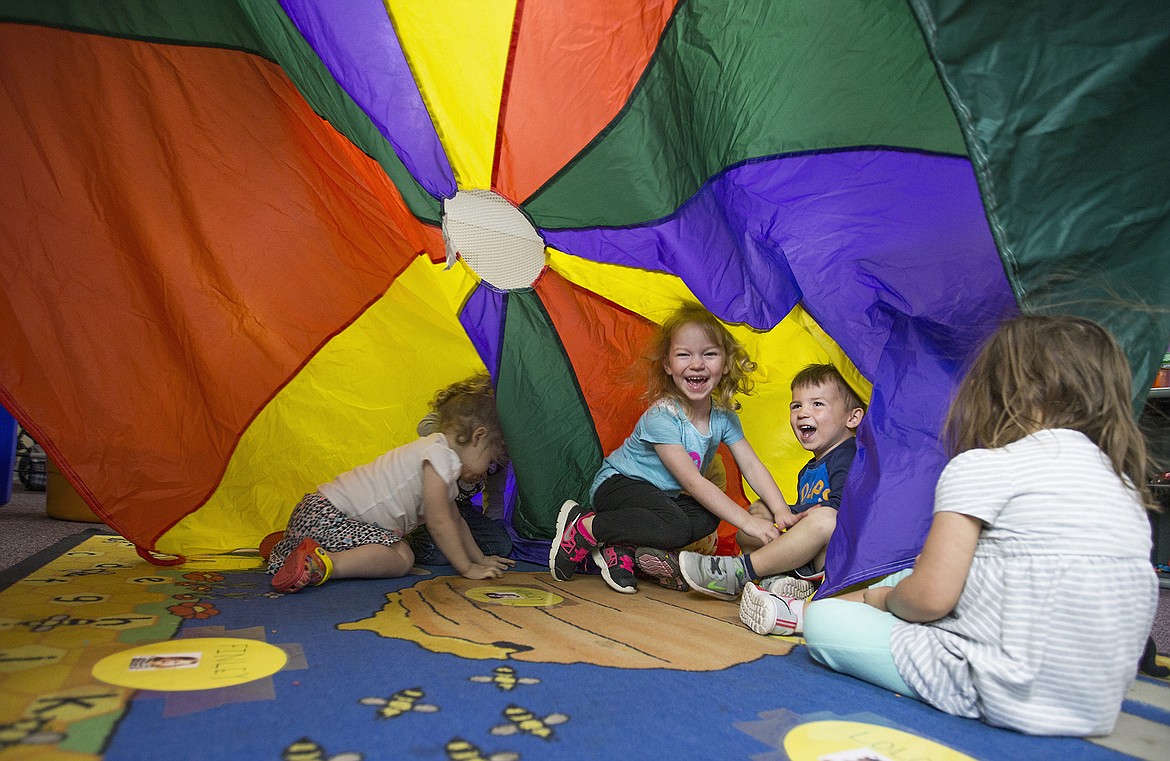 LISA JAMES/Press file
Preschoolers at Christ the King Child Development Center in Coeur d'Alene dive under a parachute after using it for a learning exercise  in this photo taken in 2017.