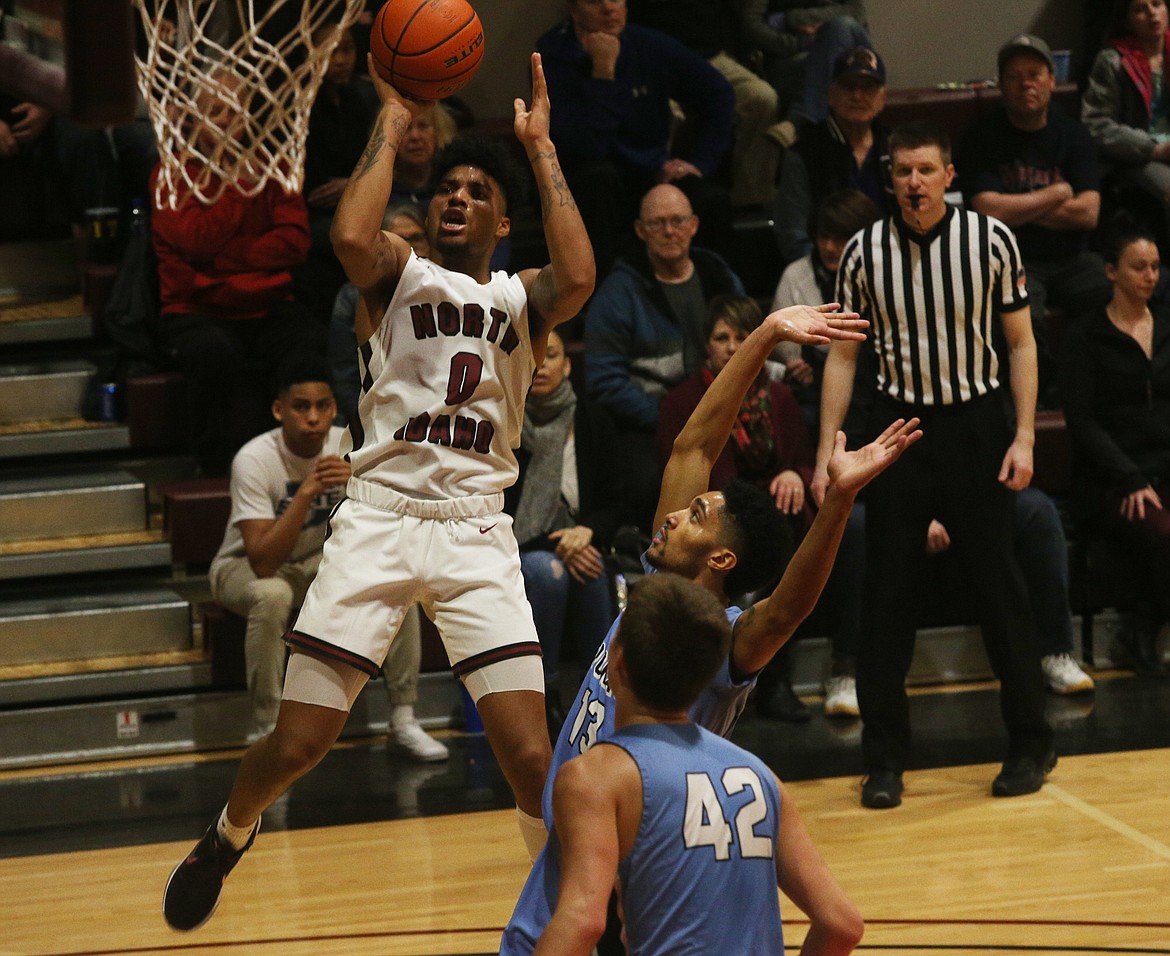 RayQuan Evans shoots a deep two over Community Colleges of Spokane's Anthony Parker. (LOREN BENOIT/Press)