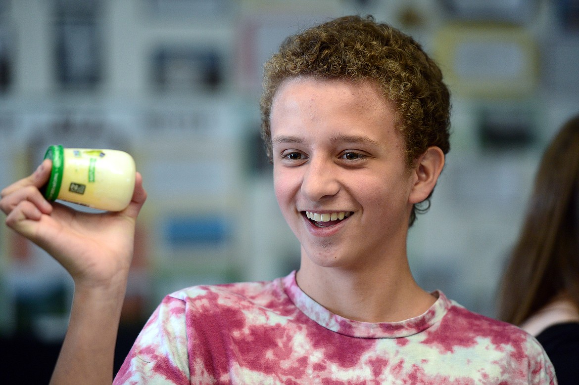 Kyler McPherson shakes a container of heavy whipping cream to make butter.