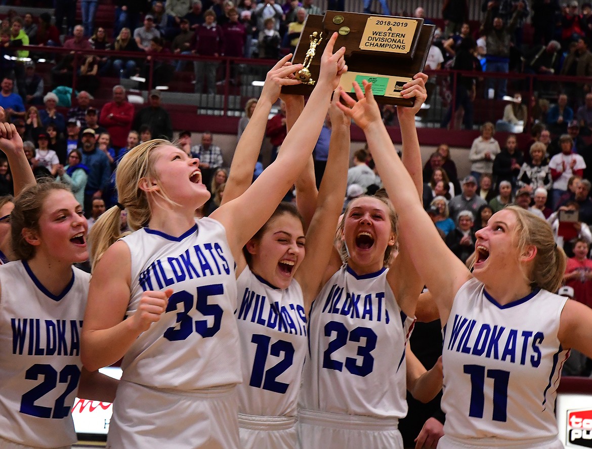 The Wildkats celebrate with the Western A Divisional basketball trophy after defeating Browning 59-52 in the title game Saturday. The Kats will face Laurel in the opening round of the state tournament in Great Falls March 7.  Pictured, from left, are Hannah Schweikert, Trista Cowan, LaKia Hill, Ryley Kehr and Savvy Ellis. (Jeremy Weber photo)