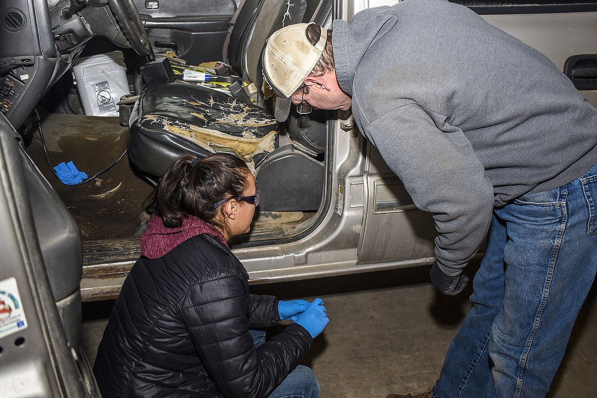 Keith Haggerty shows Troy junior student worker Izzy Ramirez where to find the recommended tire pressure on one of the school's fleet vehicles Feb. 5 while they were doing regular maintenance on the truck. (Ben Kibbey/The Western News)