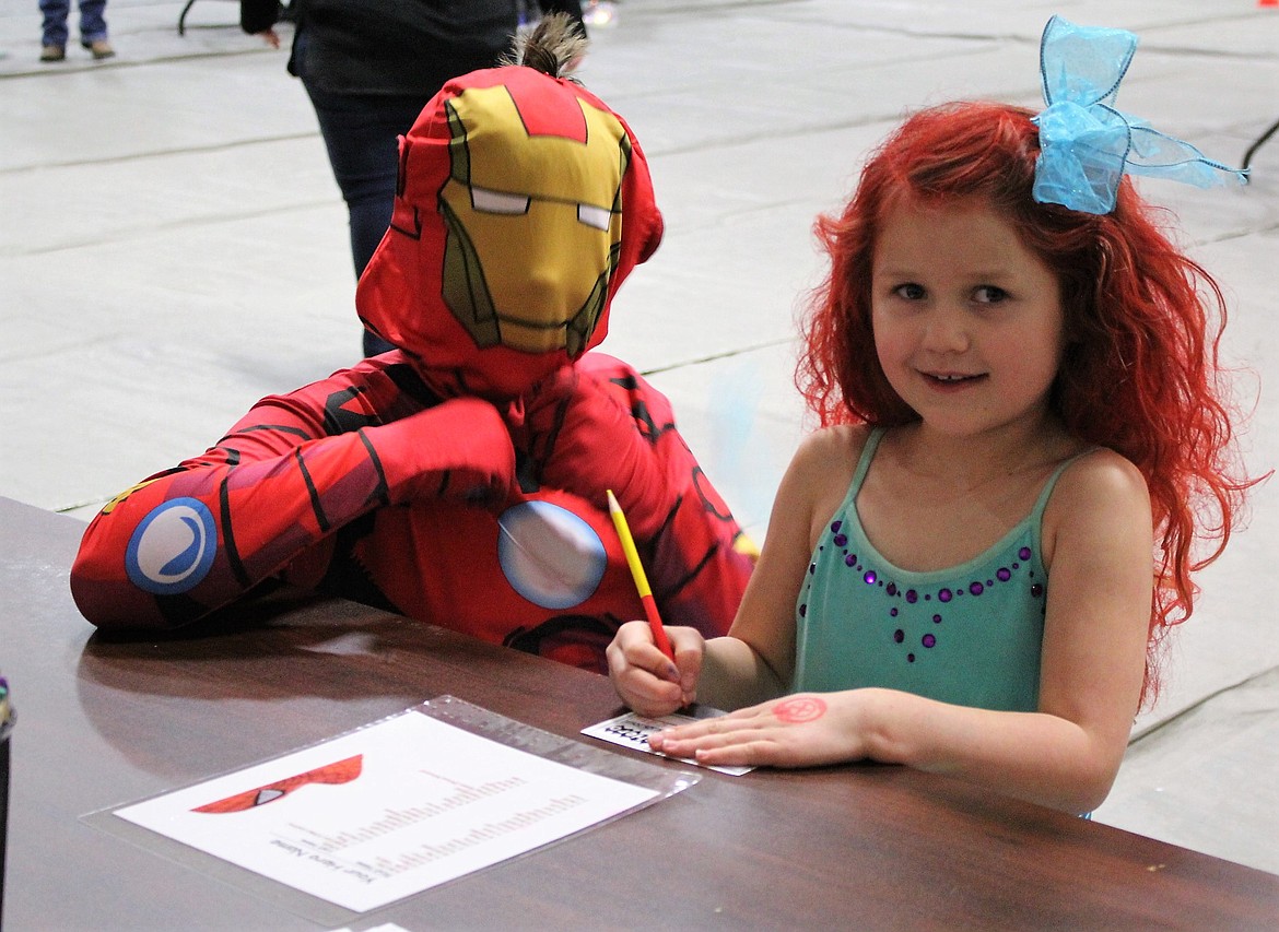 Princess Makayla and her brother Iron Man Gage Horn do a puzzle activity at the Super Hero Princess Party in Alberton on Saturday. (Kathleen Woodford photos/Mineral Independent)
