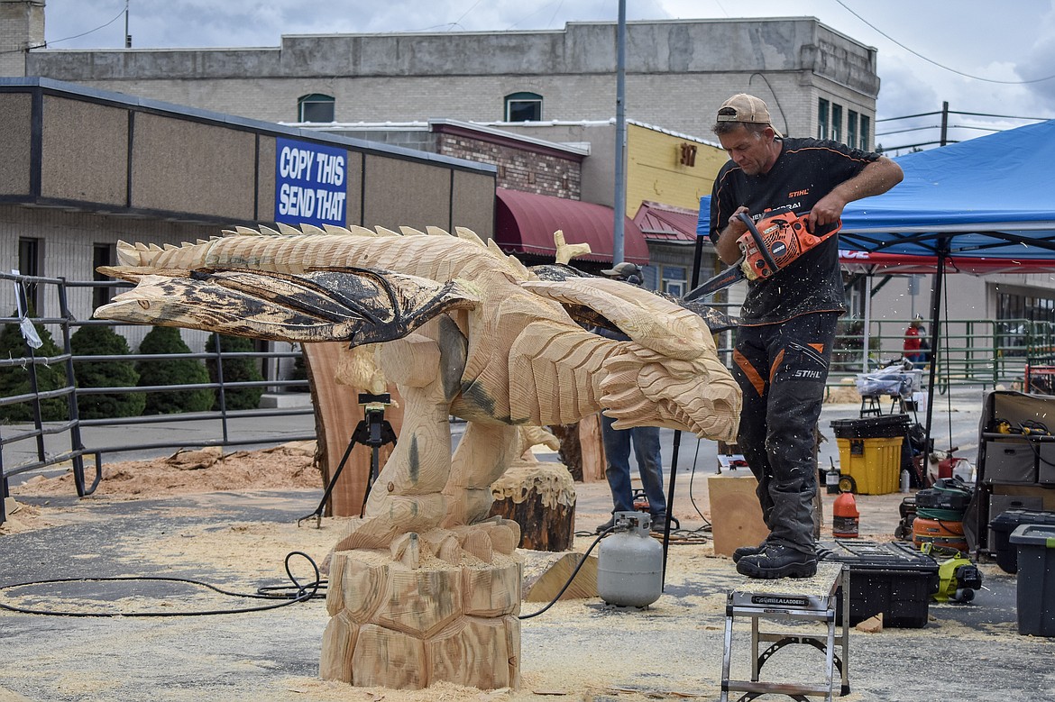 Raimondus Uzdravis from Lithuania carves on his articulated dragon during the Kootenai Country Montana Chainsaw Carving Championship on Saturday, Sept. 23, 2018. (Ben Kibbey/The Western News)