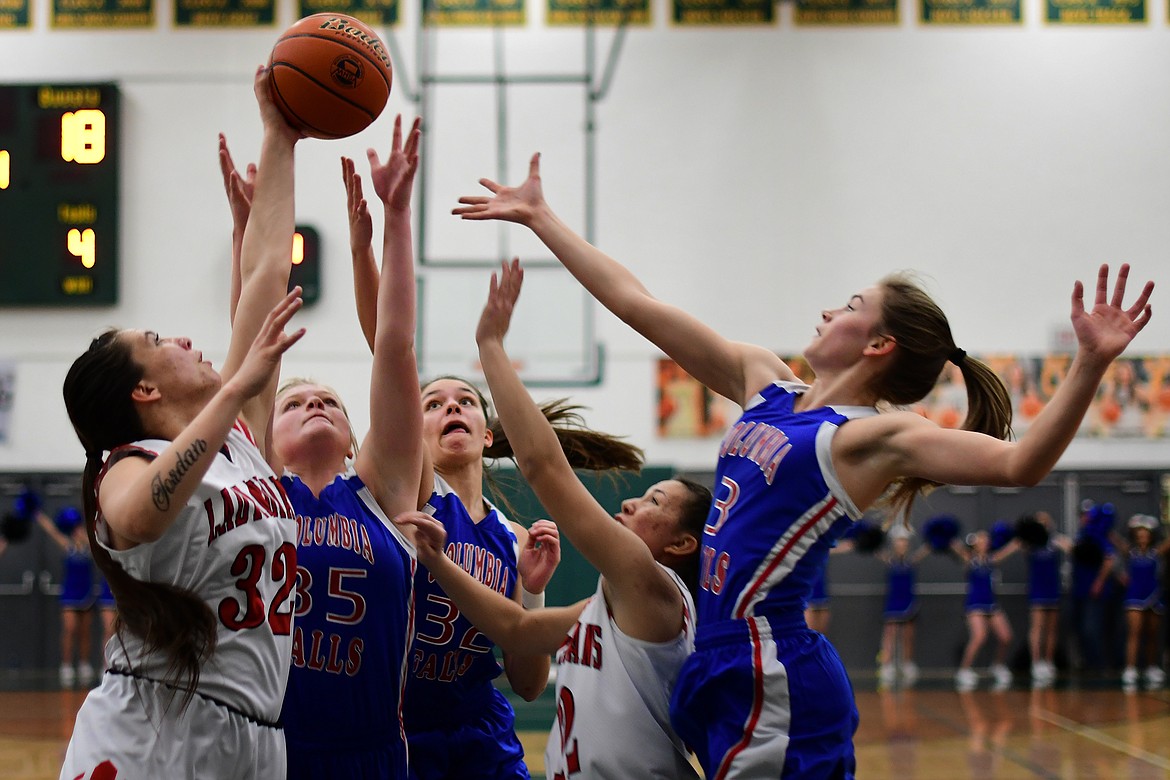 Wildkats Trista Cowan (left), Madysen Hoerner (center) and Maddie Robison battle the Lady Indians for a rebound in the first quarter Saturday. (Jeremy Weber photo)