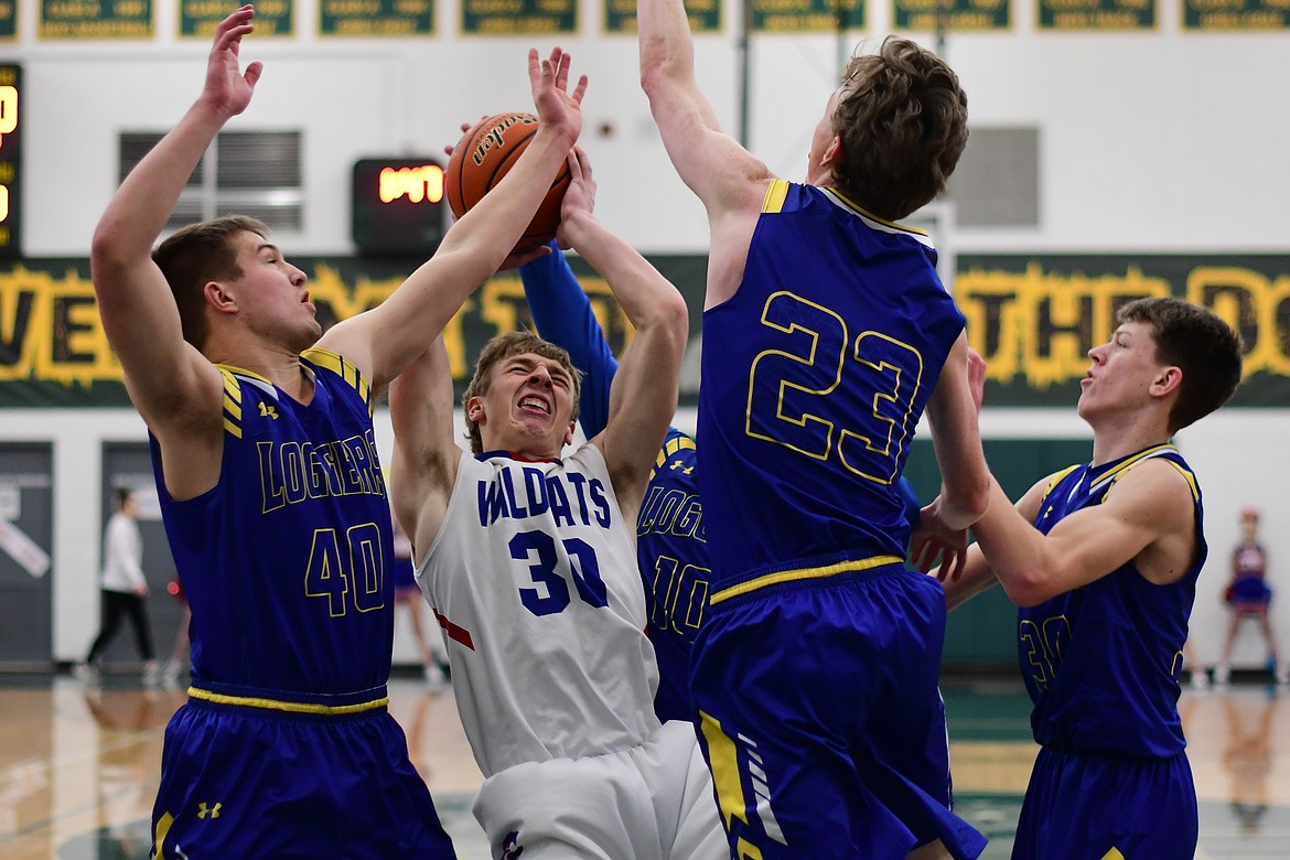 Zack Pletcher fights off a number of Libby Loggers to pull down a rebound in the second quarter Saturday. (Jeremy Weber photo)