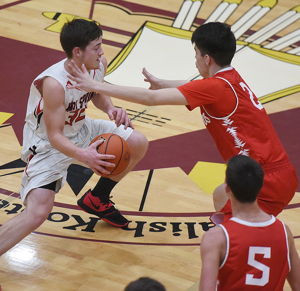 HOT SPRINGS senior Tyler Knudsen (32) makes a move on Zach Running Crane (2) of Arlee during the semifinals of the 14C District Tournament. The Warriors went to the title game with an 87-55 victory. (Joe Sova/Clark Fork Valley Press)