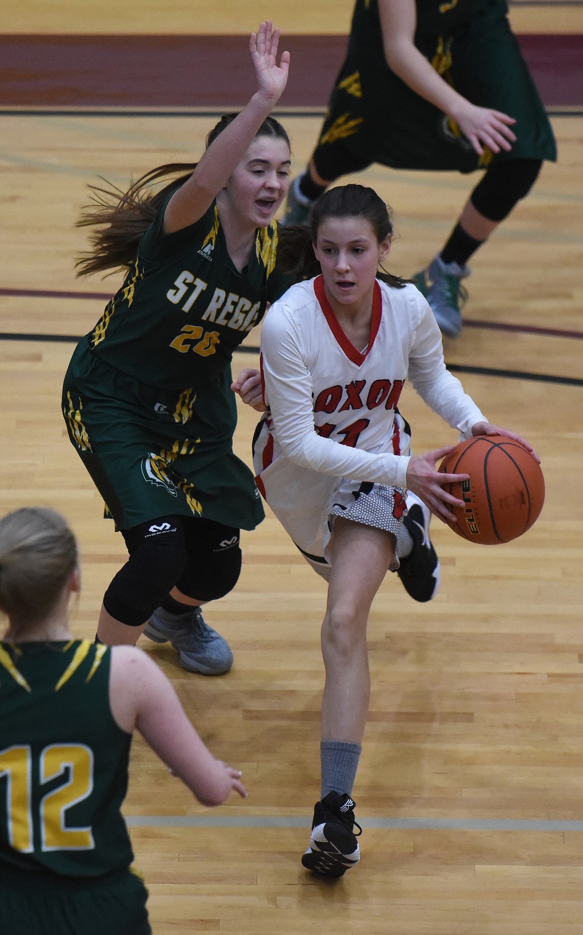 NOXON&#146;S AVERY Burgess (21), who is only an eighth-grader, drives past Makaela Kelly of St. Regis in a loser-out game at the 14C District Tournament. The Lady Tigers advanced with a 45-26 win. (Joe Sova/Clark Fork Valley Press)
