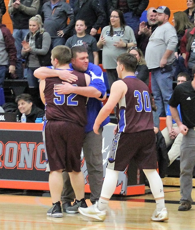 CLARK FORK Mountain Cats head coach Erik Johnson gives Korey Radford a hug after his winning basket as the Cat slipped by Victor 54-53 in their 13C District Tournament consolation game Saturday. The Cats were to face Darby on Monday in a challenge game for second place and a divisional tournament berth. (Kathleen Woodford/Mineral Independent)