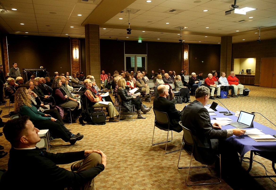 Attendees listen as developer Lanzce Douglass gives a revised presentation about the River's Edge Apartments proposal Tuesday night at The Coeur d'Alene Public Library. (LOREN BENOIT/Press)