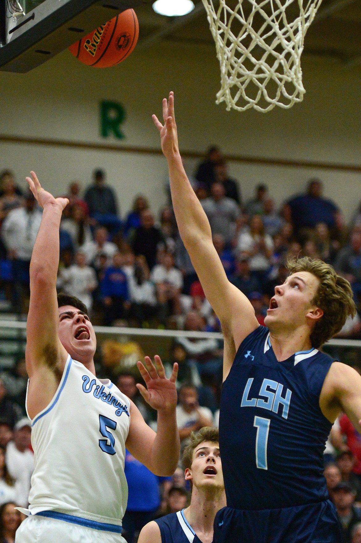 Bigfork's Luke Schmit (5) drives to the hoop with Loyola Sacred Heart's Jack Lincoln (1) defending in the State Class B boys' basketball championship at the Belgrade Special Events Center in Belgrade on Friday. (Casey Kreider/Daily Inter Lake)