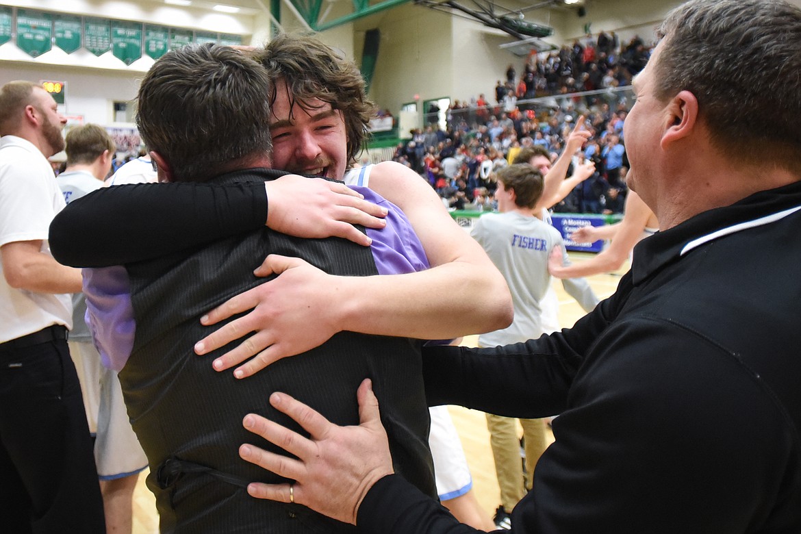 Bigfork's Anders Epperly (0) and head coach Sam Tudor celebrate after the Vikings' 47-43 victory over Loyola Sacred Heart in the State Class B boys' basketball championship at the Belgrade Special Events Center in Belgrade on Friday. At right is assistant coach Jim Epperly. (Casey Kreider/Daily Inter Lake)