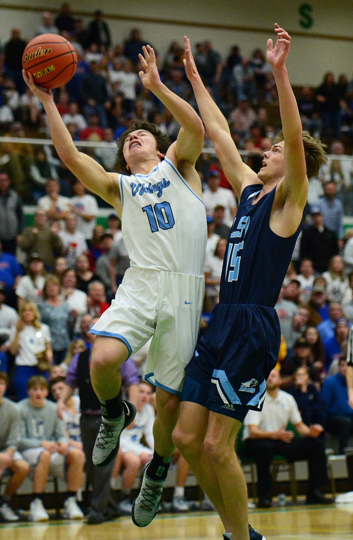 Bigfork's Randy Stultz (10) powers to the hoop past Loyola Sacred Heart's Cooper Waters (15) in the State Class B boys' basketball championship at the Belgrade Special Events Center in Belgrade on Friday. (Casey Kreider/Daily Inter Lake)