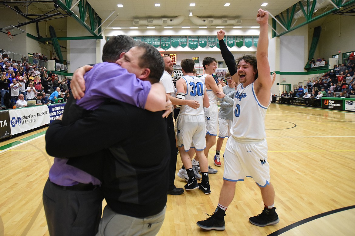 Bigfork head coach Sam Tudor, left, and assistant coach Jim Epperly embrace as Bigfork celebrates after its 47-43 victory over Loyola Sacred Heart in the State Class B boys' basketball championship at the Belgrade Special Events Center in Belgrade on Friday. (Casey Kreider/Daily Inter Lake)