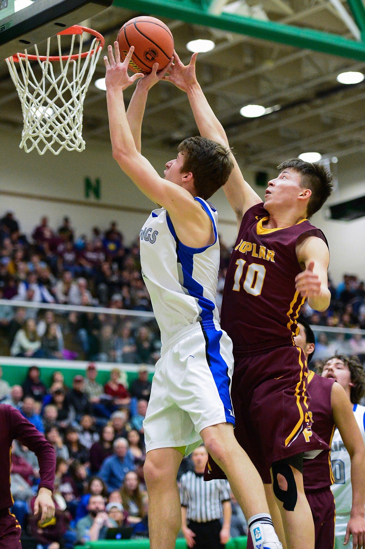 Bigfork's Colton Reichenbach (3) drives to the hoop against Poplar's Wynn Main (10) in the State Class B Boys' Basketball Tournament at the Belgrade Special Events Center in Belgrade on Thursday. (Casey Kreider/Daily Inter Lake)