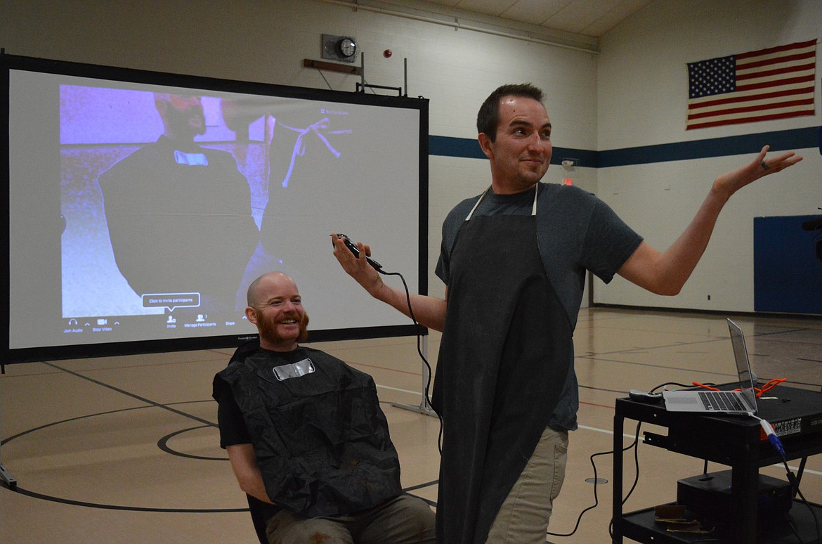 Bronson Ericksen, steps back to show an assembly of Bigfork Middle School Students the newly shaven Patrick Johnston. Johnston agreed to let students vote on what shape he would shave his beard based on which style raised the most money, or votes, for his &#147;beard-raiser.&#148;