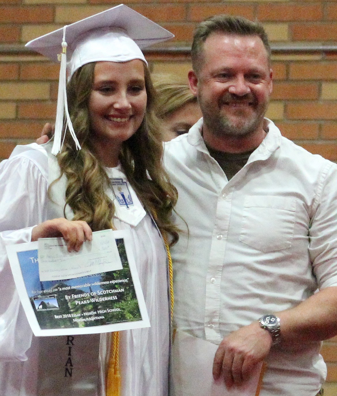FSPW Sanders County Outreach Coordinator Ray Brown awards Phalyn her check at her graduation from Noxon High School. (Courtesy photo)