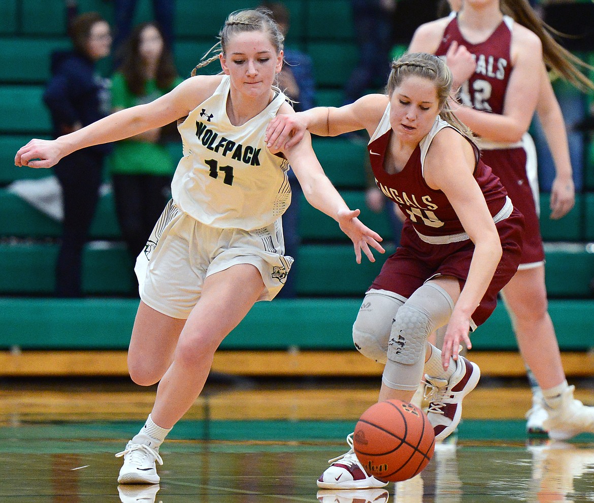 Glacier's Kaileigh Crawford (11) and Helena High's Paige Aasved (10) reach for a loose ball during Western AA Divisional play at Glacier High School on Saturday. (Casey Kreider/Daily Inter Lake)