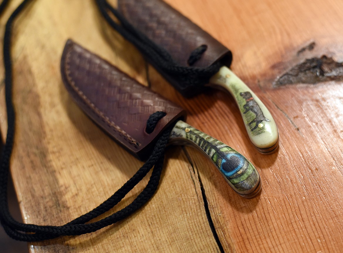 Examples of two knifes by scrimshaw artist Kate Opre. The peacock feather was created for her stepmother, and she added the family dog to a knife for her father.