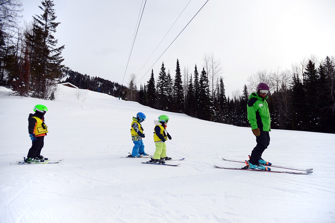 Young skiers follow an instructor down a hill near the Big Easy Conveyor Carpet during the Buckaroo Ski Program at Whitefish Mountain Resort on Wednesday, Feb. 27. (Casey Kreider/Daily Inter Lake)