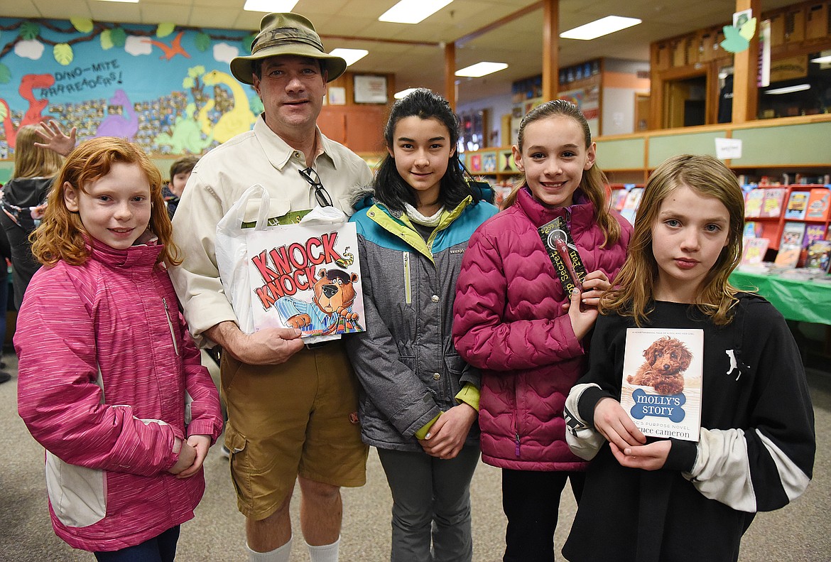 PLAINS SCHOOLS Superintendent Thom Chisholm, an &#147;Indiana Jones&#148; lookalike for the I Love to Read assembly last Friday, was in the school library to purchase books for his grandkids during the Book Fair. Chisholm is pictured with, from left, fifth graders Sarah Anderson, Jamie Christensen, Katelyn Subatch and Araeys King. (Joe Sova/Clark Fork Valley Press)