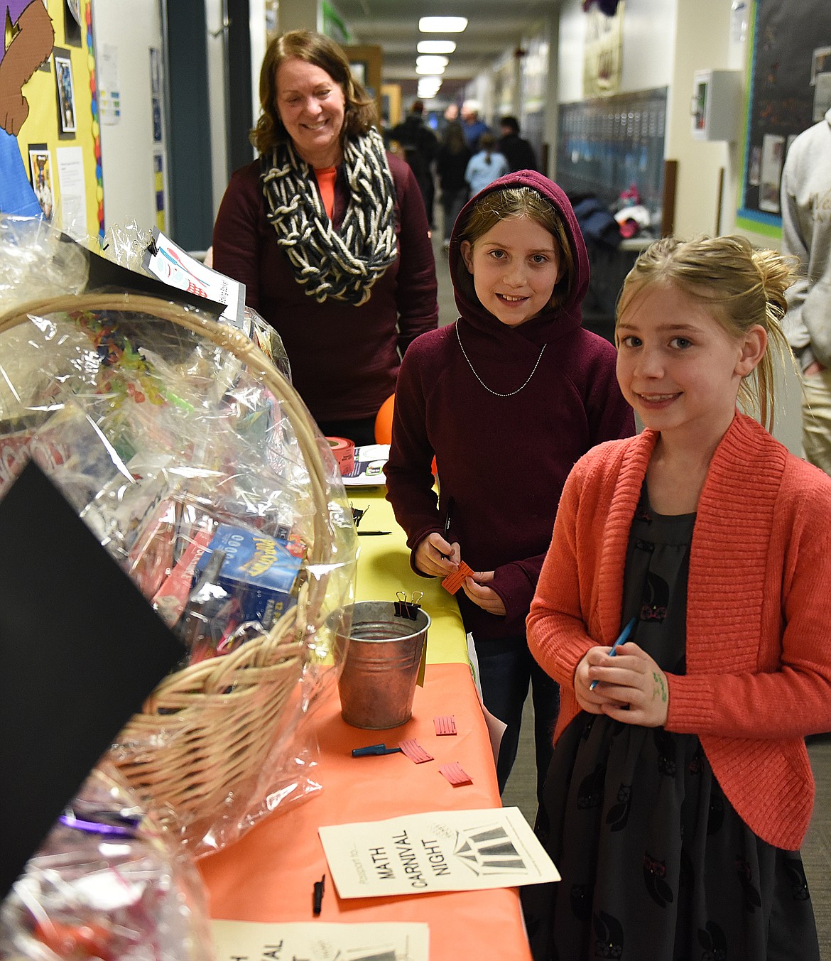 MATH CARNIVAL Night at Linderman Elementary School was a &#147;passport&#148; for fun for kids and parents. Above, third grader Jasmyn Allred and sister Isabella, a fourth grader, register with hopes of winning a gift basket. PE teacher Micki Stanley is in the background.