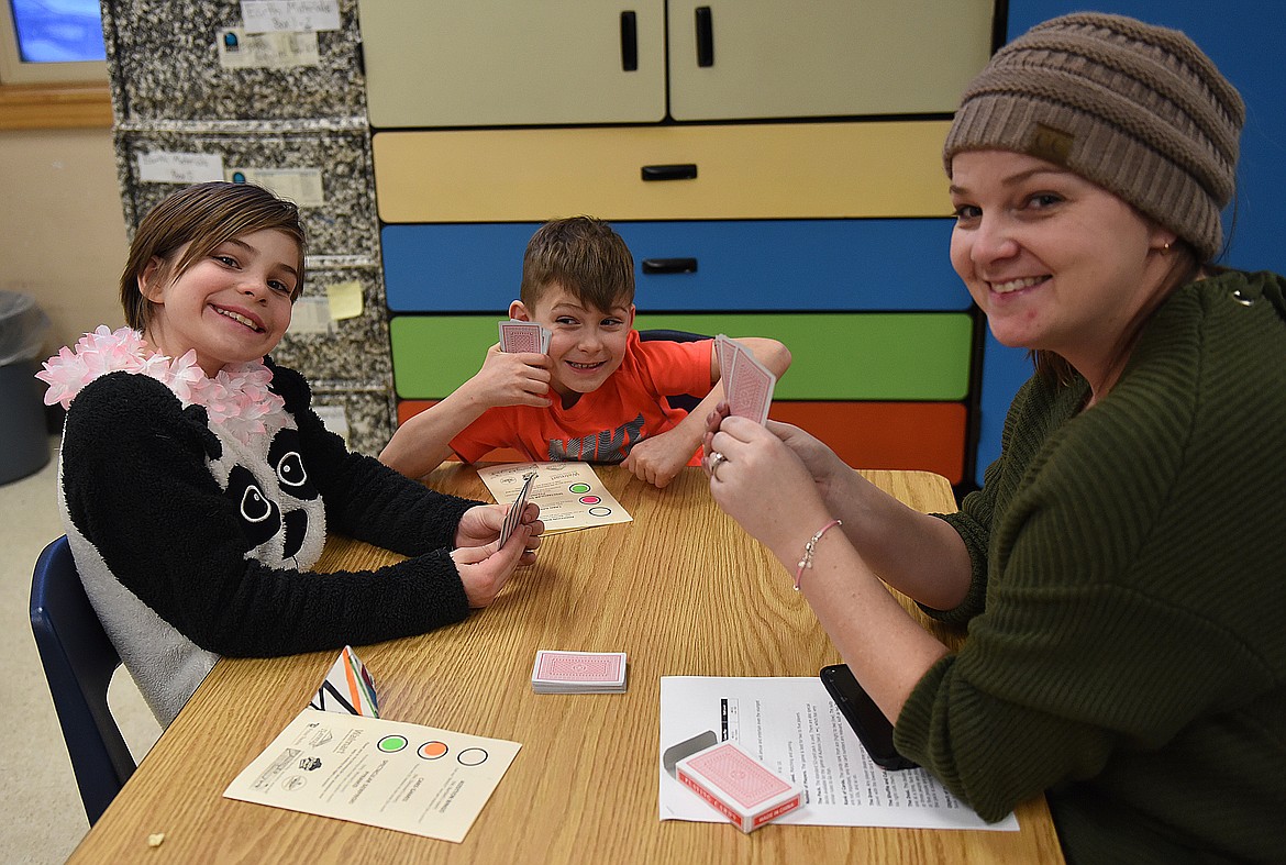 MEMBERS OF the Combs family Charlotte, Mason and mom Amanda play &quot;Go Fish&quot; during a Math Carnival Night activity at Linderman Elementary School.