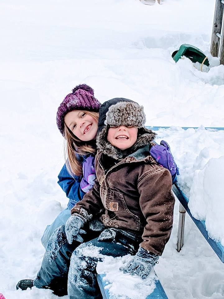 Piper (6) and Boaz (4) McGuffey from St. Regis are all smiles playing in the snow despite freezing temperatures last week. (Photo courtesy of Rebekah Kay McGuffey)