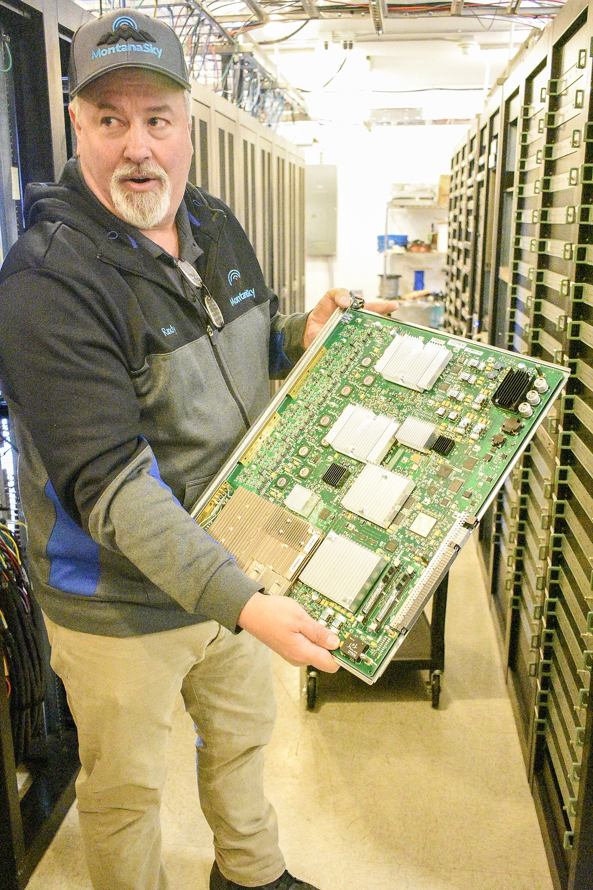 Montana Sky headend technician Randy Lindsey shows one of the "cards" that was part of the recent upgrade Montana Sky made at their Libby headend, allowing them to double bandwidth they could provide to customers. (Ben Kibbey/The Western News)