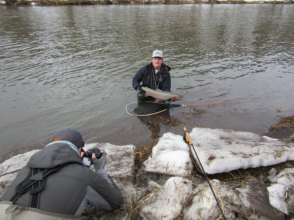 (Photo courtesy of IDAHO FISH &amp; GAME)
An angler lifts a steelhead out of the water for a picture and is timed by a researcher. A study by the Idaho Department of Fish and Game found such practices did not effect survival of the fish or the fitness of their offspring.