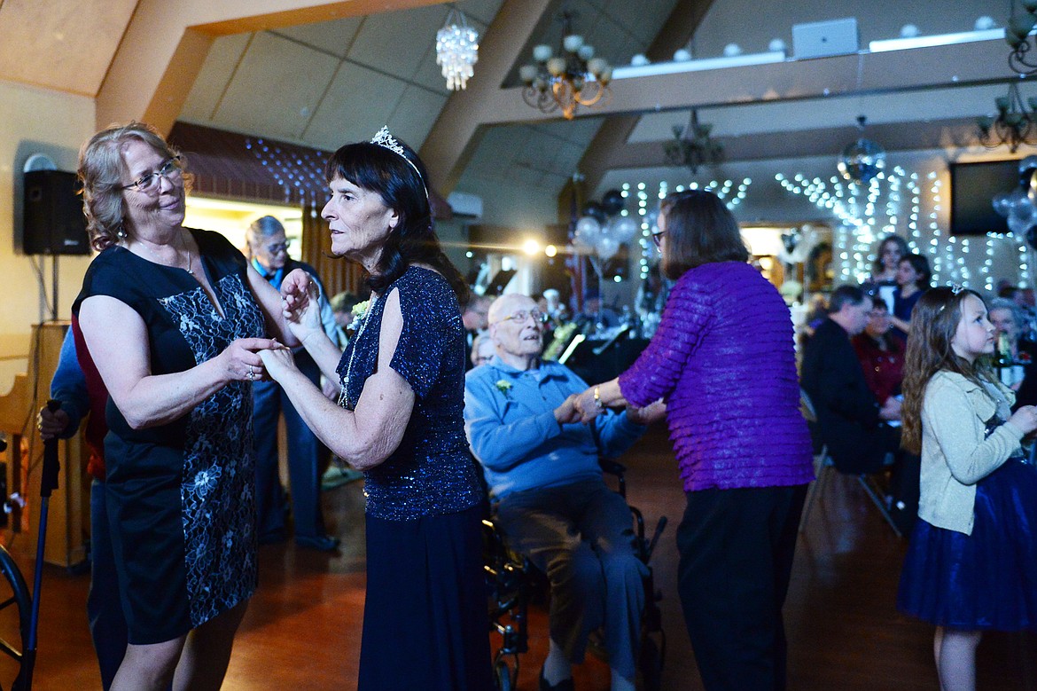 Angie Conte, right, dances with her sister and guest Joanie Hall during the Senior's Ball at the Immanuel Skilled Care Center at Immanuel Lutheran Communities in Kalispell on Friday. (Casey Kreider/Daily Inter Lake)