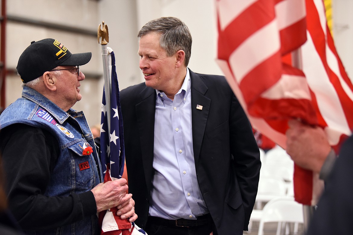 Senator Steve Daines speaks with Vietnam Veteran Leo Schaefer of Kalispell as they await the arrival of the Montana National Guard 495th Combat Sustainment Support Battalion on Saturday night, March 16. Schaefer and other members of the Vietnam Veterans of America NorthWest Montana Chapter 1087 presented a line of American flags to welcome the soldiers home. More than one of them expressed their belief in the importance of honoring the soldiers this way because American military personnel who served in Vietnam were most often not welcomed home.(Brenda Ahearn/Daily Inter Lake)